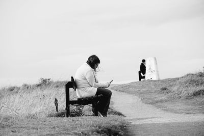 Rear view of people sitting on land