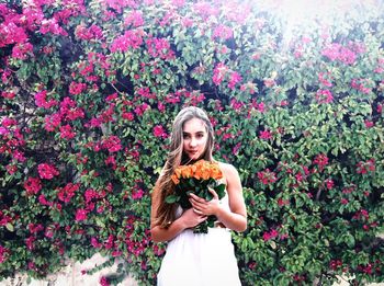 Portrait of woman holding plant