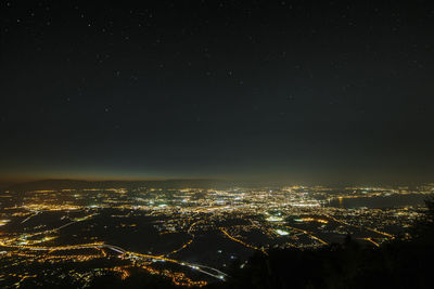 Aerial view of illuminated cityscape against sky at night