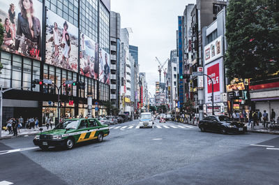 Cars on street in city against sky