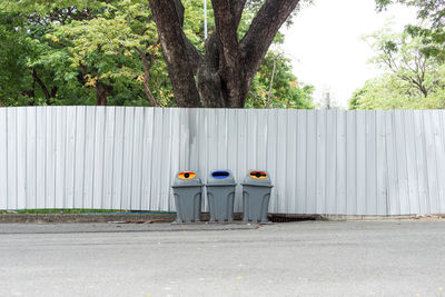 Garbage bin against trees and plants