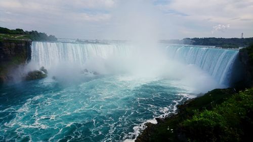 Scenic view of waterfall against sky