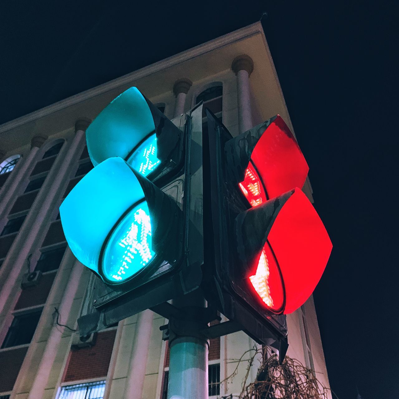 stoplight, sign, illuminated, light, low angle view, lighting, road sign, road signal, guidance, communication, red light, architecture, city, blue, display device, traffic light, green light, no people, lighting equipment, road, building exterior, night, built structure, red, signaling device, signage, light fixture, street, transportation, city life, stop sign, symbol, light - natural phenomenon, outdoors, directional sign, sky