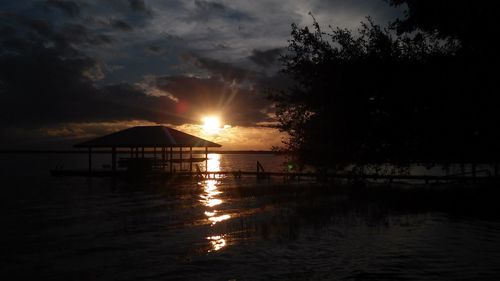 Sun shining through clouds over sea