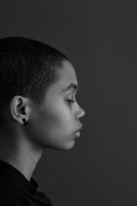 Profile view of woman against gray background