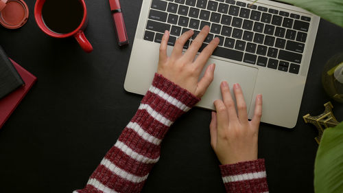 Cropped hands using laptop at desk