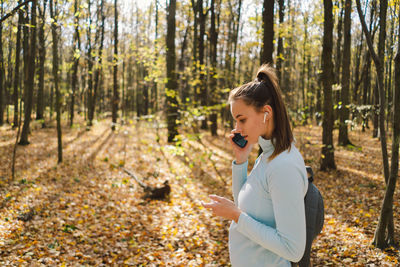 Beautiful girl uses phone for fitness or yoga.