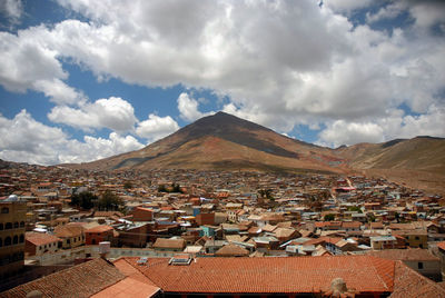 Aerial view of townscape and mountains against sky