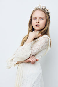 Portrait of young woman standing against white background