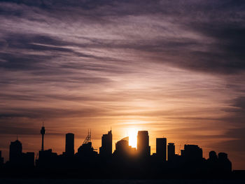 Silhouette of buildings against sky at sunset