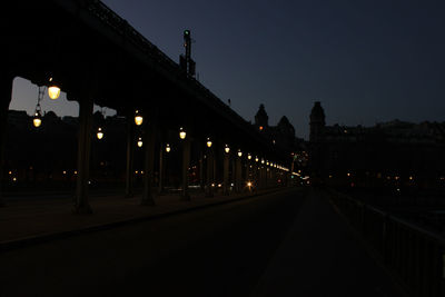 Illuminated road against sky in city at night