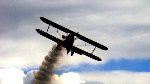 Low angle view of airplane flying against cloudy sky