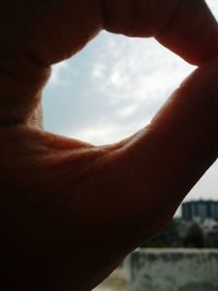 Cropped image of hand looking through window