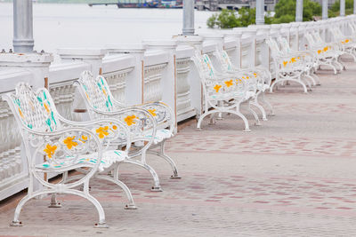 Empty chairs and tables on street in city