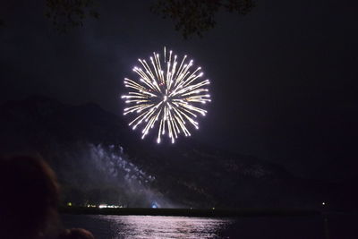 Firework display over river at night