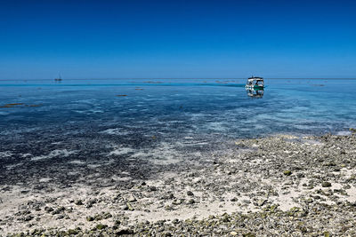 Scenic view of sea against clear blue sky