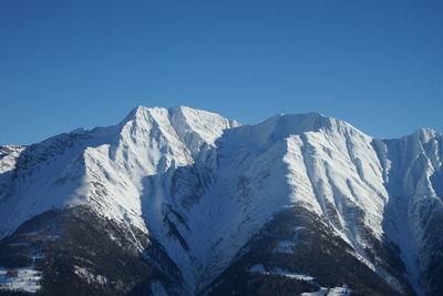 Scenic view of snowcapped mountains against clear blue sky