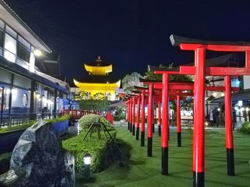 Illuminated red building against sky at night