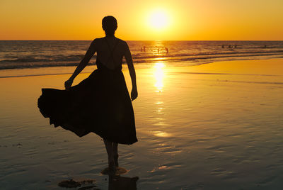 Man standing on beach during sunset