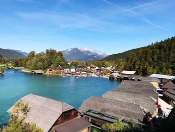 Panoramic view of lake and buildings against blue sky