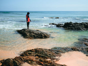 Rear view of man walking on beach