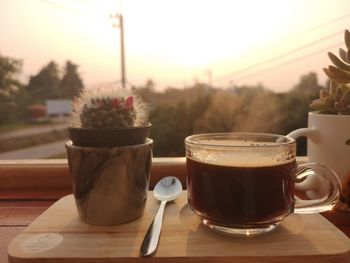 Close-up of coffee served on table against sky during sunset