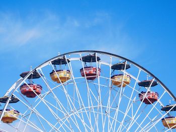 Low angle view of ferris wheel against blue sky