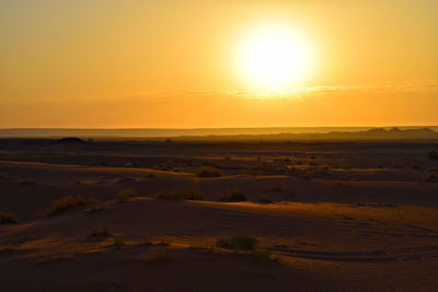 Scenic view of desert against sky during sunset