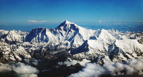 Scenic view of snowcapped mountains against blue sky