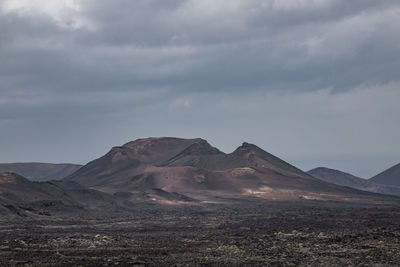View of volcanic landscape against cloudy sky