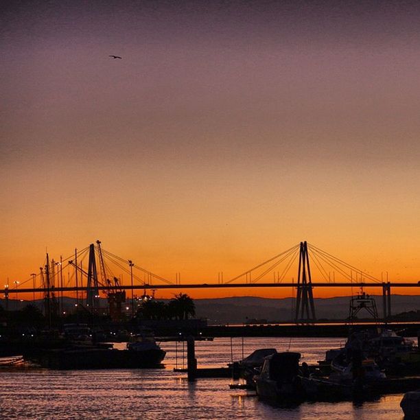 sunset, connection, transportation, bridge - man made structure, water, built structure, architecture, engineering, orange color, suspension bridge, bridge, clear sky, copy space, silhouette, river, waterfront, mode of transport, travel destinations, sky, sea