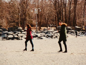 Rear view of people walking on snow covered land