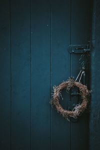 Close-up of wreath hanging on wood paneling