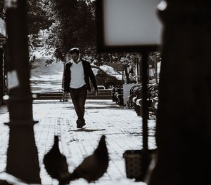 Rear view of woman walking on footpath