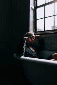 Portrait of man sitting in bathroom at home