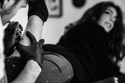 Man tattooing on woman leg