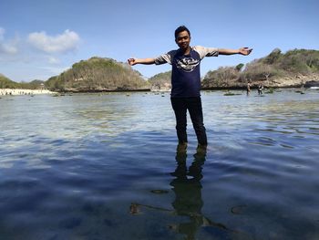 Full length of man standing on lake against sky