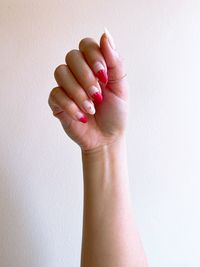 Close-up of woman hand against white wall