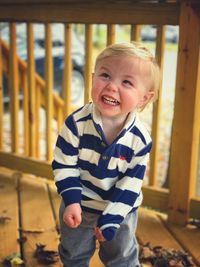 Blonde toddler boy in striped shirt laughing