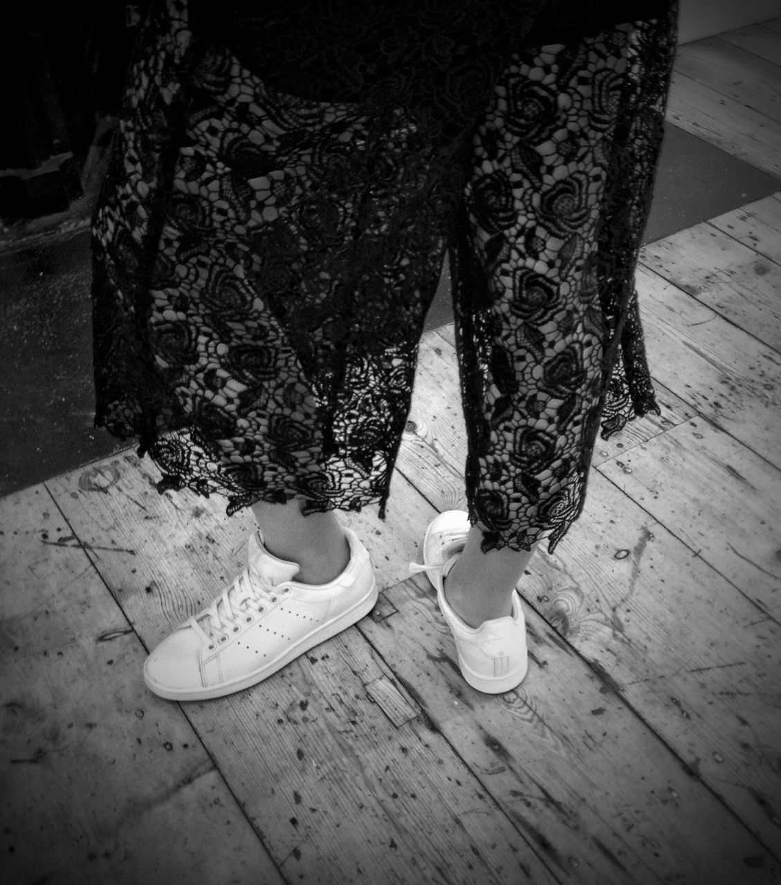 LOW SECTION OF WOMAN STANDING ON TILED FLOOR