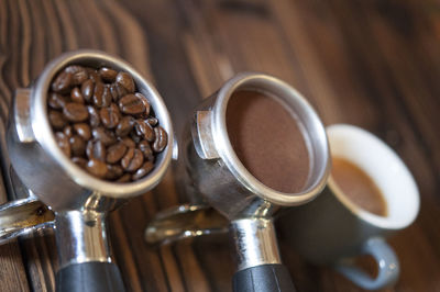 High angle view of coffee in containers on wooden table in cafe