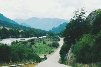 Scenic view of mountains by river against sky