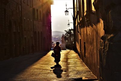 Man walking on street amidst buildings in city