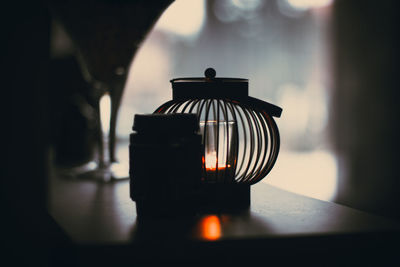 Candle in lantern on table