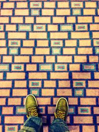 Low section of man standing on colorful carpet