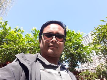 Portrait of man wearing sunglasses against sky