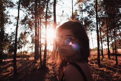 Side view portrait of young woman standing in forest