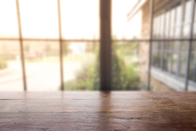 Close-up of wooden table against window