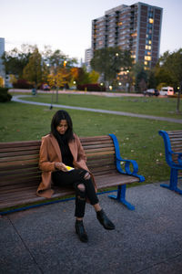 Woman sitting on bench in park
