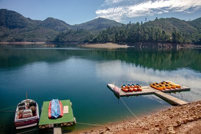 Scenic view of lake by mountains against sky